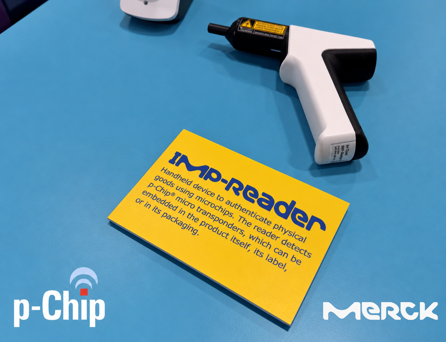 A handheld IM-Reader beside a yellow product information card, with p-Chip and Merck branding.